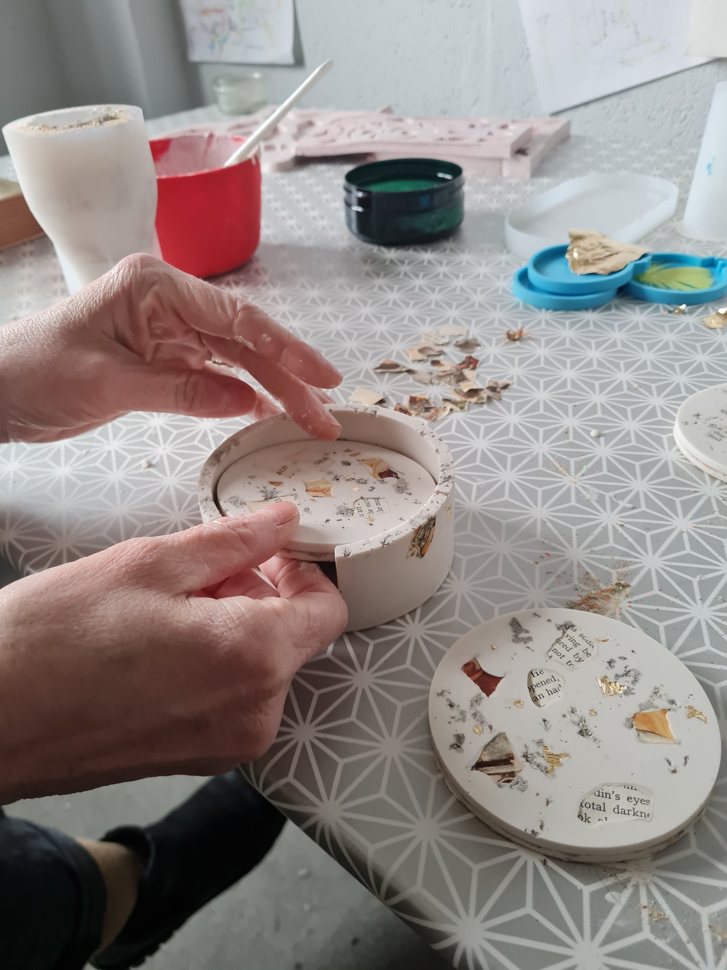 Hands putting a freshly made Jesmonite coaster in a Jesmonite coaster holder